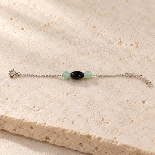 Black oval bead with mint round side beads on a silver chain, with clasp and extender.